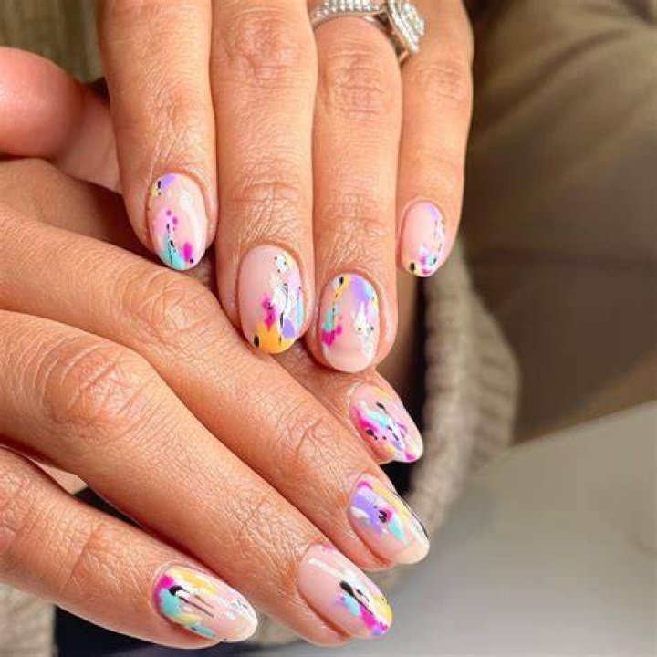 Abstract watercolor ink nail art with blended brushstroke designs in earthy tones